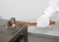 Copper-bonded tape being bent in a bending tool